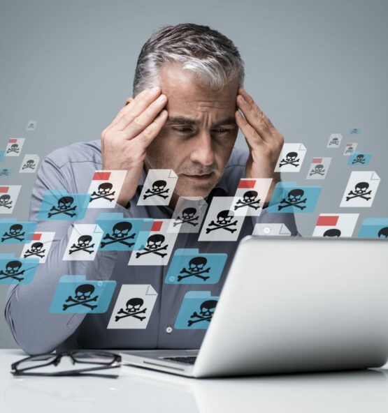 Businessman working with a computer full of viruses, infected files and malwares: he is frustrated with head in hands
